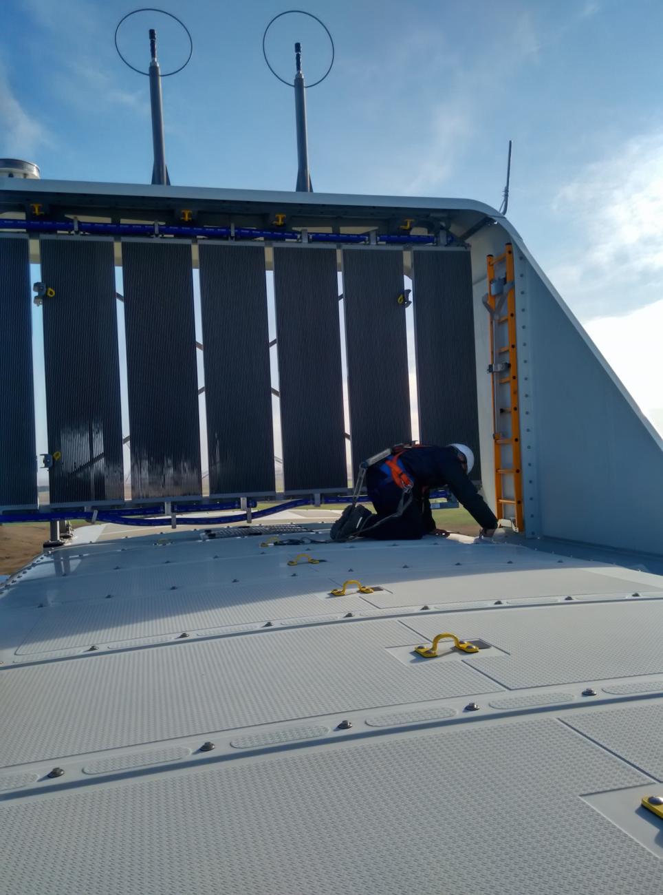 Técnico con arnés trabajando sobre la góndola de un aerogenerador