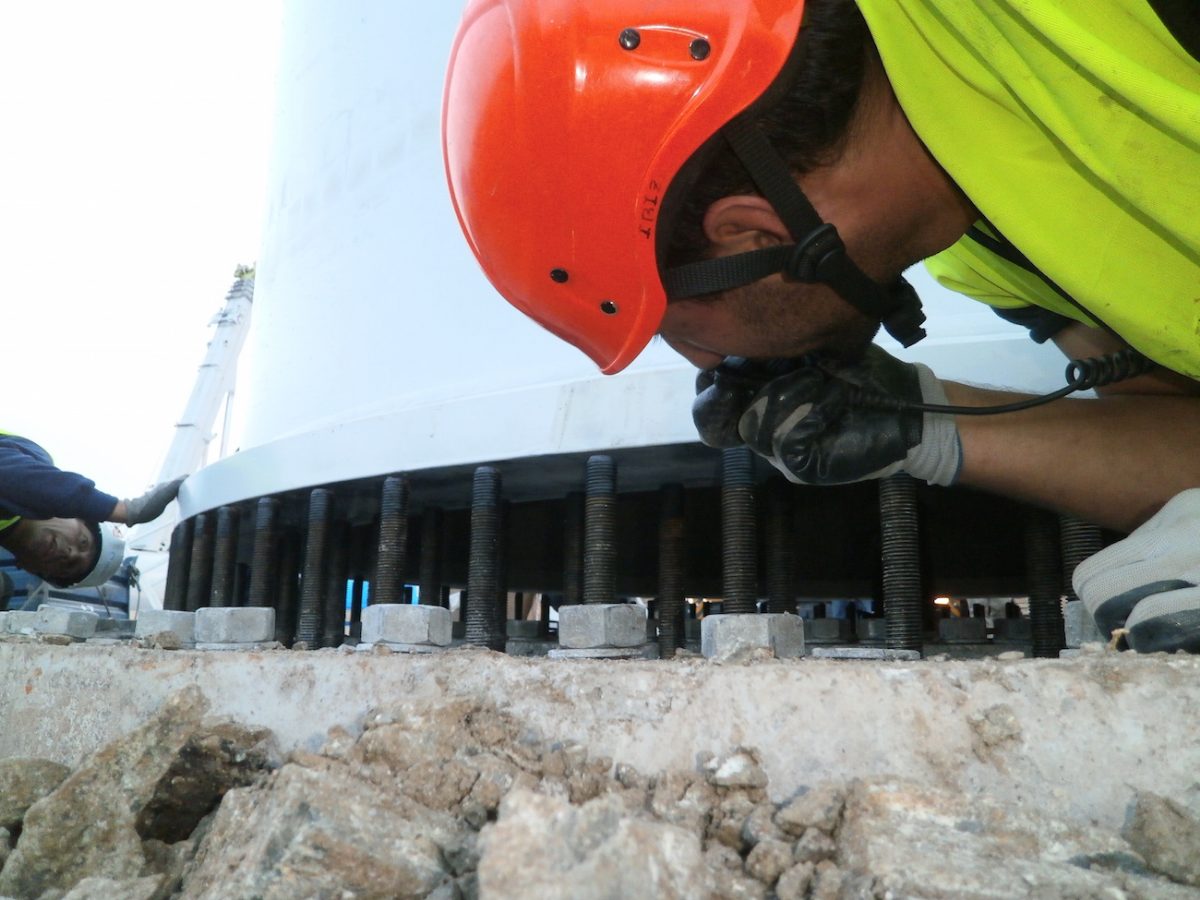 Técnico de Greenwork con EPIs completos apretando la brida de un aerogenerador