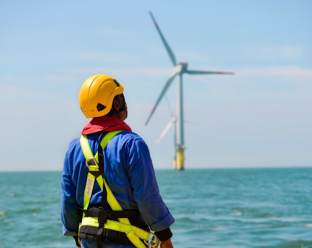 Técnico con arnés, casco y EPIs completos en un aerogenerador