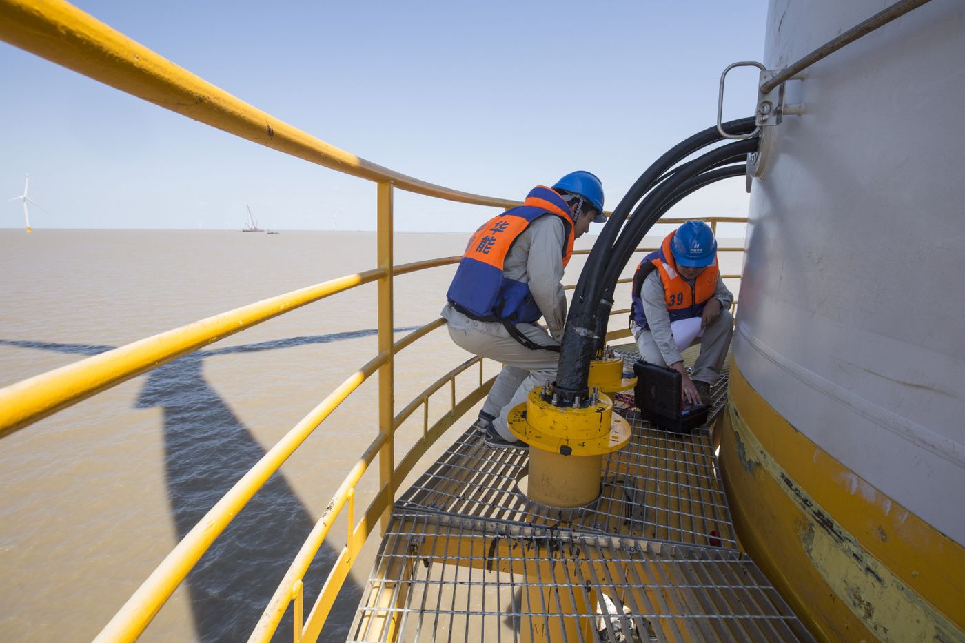 Técnico con casco y EPIs completos trabajando en el interior de una góndola de aerogenerador